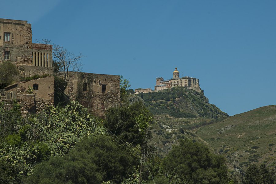 Historische Anlage auf einem Hügel inmitten grüner Hänge auf Sizilien